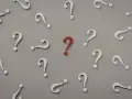 Czerwony znak zapytania wyróżnia się wśród białych. Czy to symbol trudnego pytania na egzaminie licencjackim?