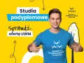 Uśmiechnięty mężczyzna w koszulce UWM zachęca do sprawdzenia oferty studiów podyplomowych. Dowiedz się, studia podyplomowe co to i rozwijaj się!