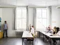 Nauczyciel pyta, ile frekwencji żeby zdać. Uczniowie podnoszą ręce, gotowi do odpowiedzi.