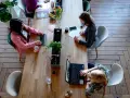 Kobiety pracują przy drewnianym stole. Jedna pisze na laptopie, druga notuje. To przykład, jak etyka co to, wpływa na codzienne zadania.