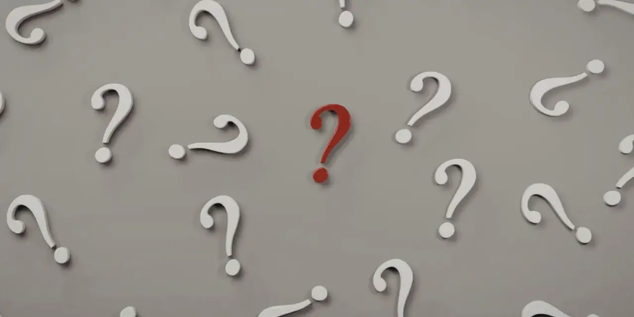 Czerwony znak zapytania wyróżnia się wśród białych. Czy to symbol trudnego pytania na egzaminie licencjackim?