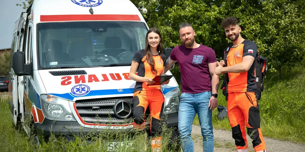 Trzech ratowników medycznych przy ambulansie. Zastanawiasz się, ile zarabia ratownik medyczny?