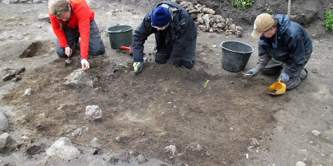 Antropologowie pracują na stanowisku archeologicznym, ostrożnie badając ziemię.