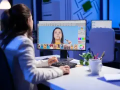 Kobieta edytuje zdjęcia na komputerze, zastanawiając się, ile zarabia grafik komputerowy.