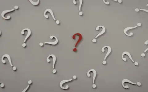 Czerwony znak zapytania wyróżnia się wśród białych. Czy to symbol trudnego pytania na egzaminie licencjackim?