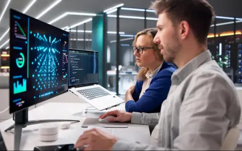 Dwóch inżynierów pracuje nad projektem, analizując dane na ekranach.