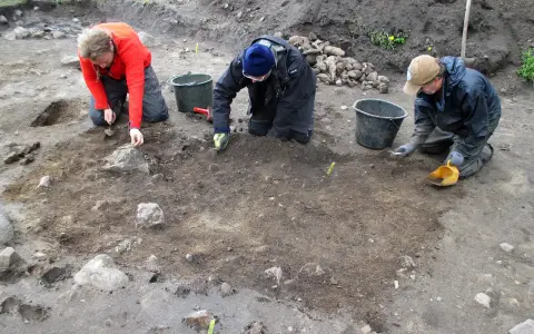 Antropologowie pracują na stanowisku archeologicznym, ostrożnie badając ziemię.