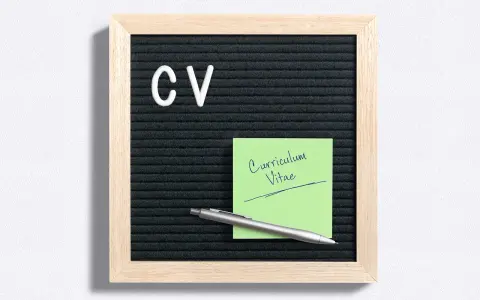 Tablica z literami "CV" i zielona karteczka z napisem "Curriculum Vitae". Idealne do przygotowania CV po niemiecku.