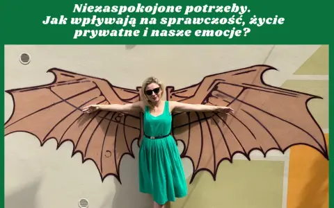 Kobieta w zielonej sukience stoi przed muralem z brązowymi skrzydłami.