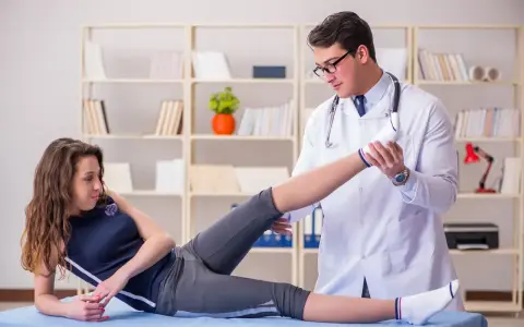 Fizjoterapeuta wykonuje ćwiczenia z pacjentką w gabinecie.