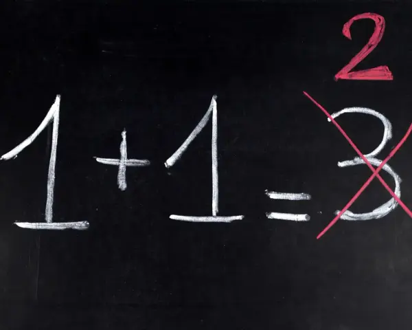 Na czarnej tablicy napisano kredą: 1+1=3. Dwójka jest podkreślona na czerwono, a trójka przekreślona. Jak na egzaminie dojrzałości, gdzie liczy się poprawna odpowiedź.