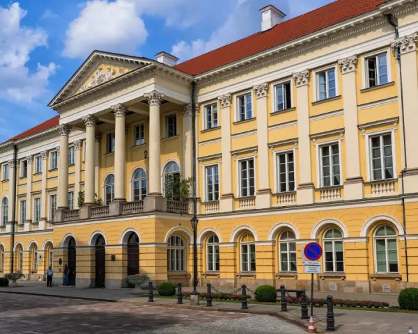 Imponujący żółty budynek z kolumnami, symbol jednych z najlepszych uczelni w Polsce.