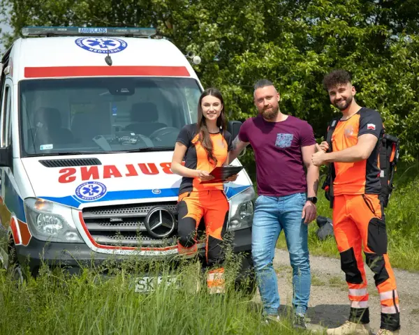 Trzech ratowników medycznych przy ambulansie. Zastanawiasz się, ile zarabia ratownik medyczny?