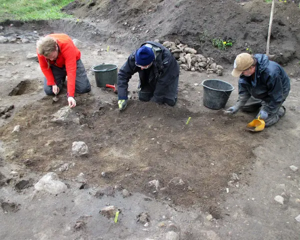 Antropologowie pracują na stanowisku archeologicznym, ostrożnie badając ziemię.