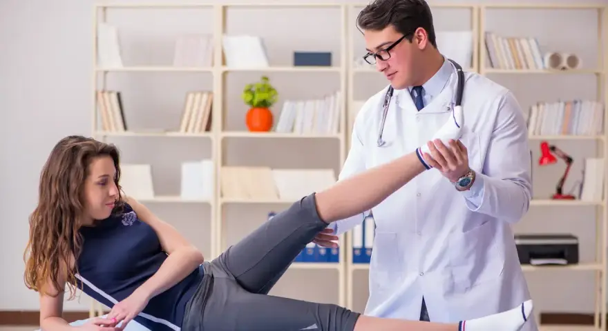 Fizjoterapeuta wykonuje ćwiczenia z pacjentką w gabinecie.