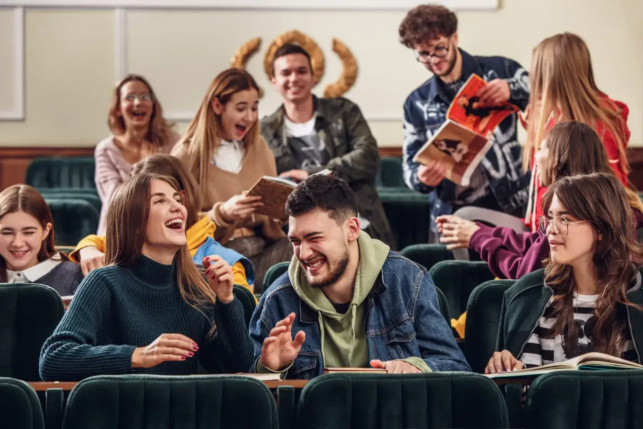 Studenci śmieją się podczas wykładu, być może omawiając materiał do licencjatu.